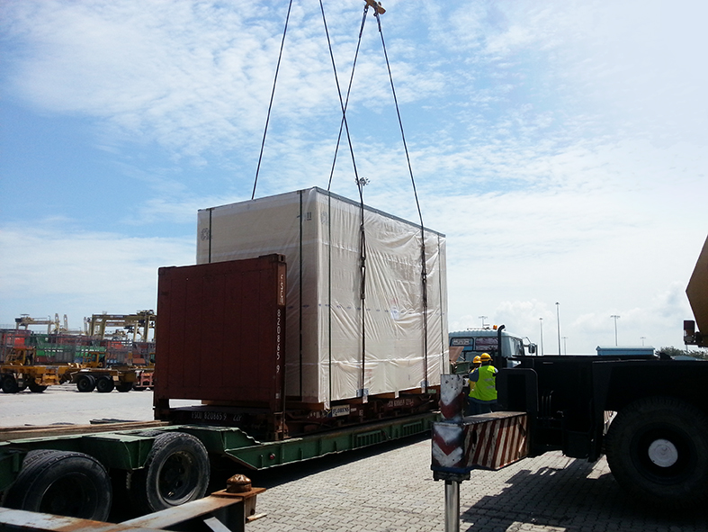 Loading large crate with the help of mobile crane.