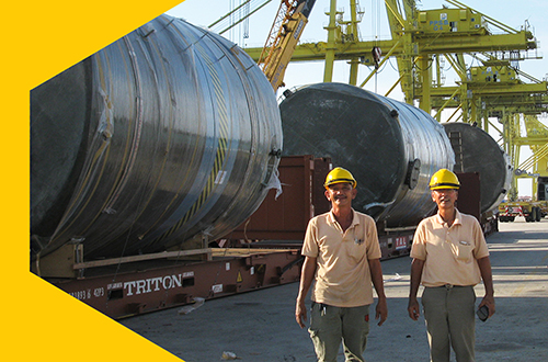 Popular Pack company leader standing in front of tank for shipment in a port.